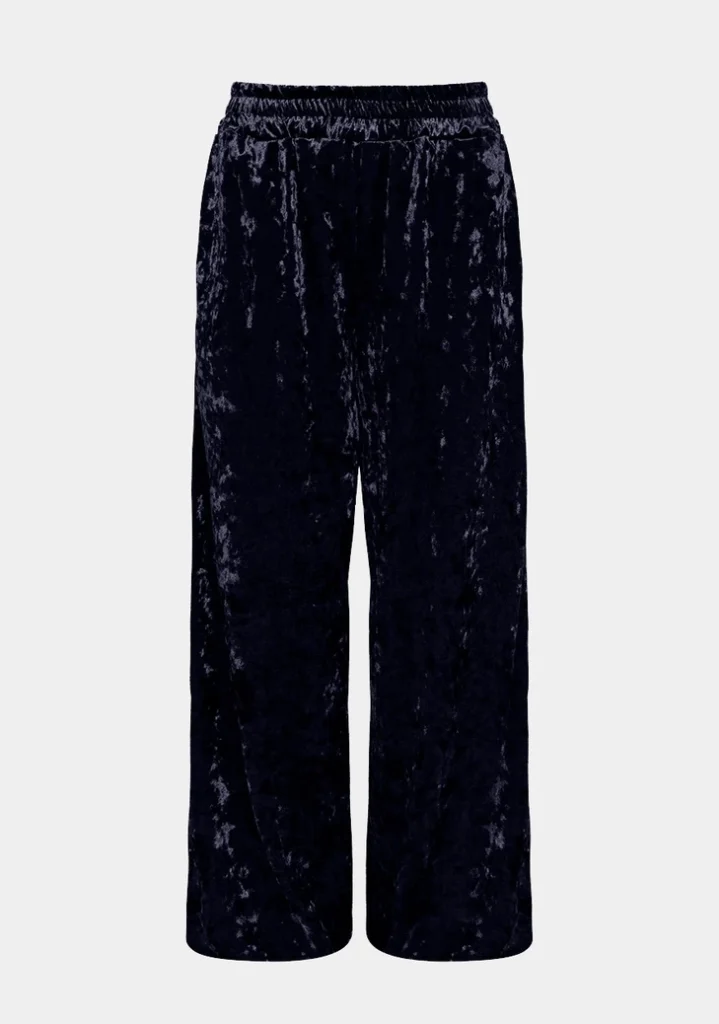 Calça pantalona de veludo azul-marinho com cintura elástica e pernas amplas de caimento reto, fotografada em fundo cinza claro.