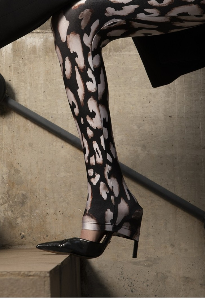 Close da perna com legging animal print em tons de preto e bege, combinada com scarpin preto.